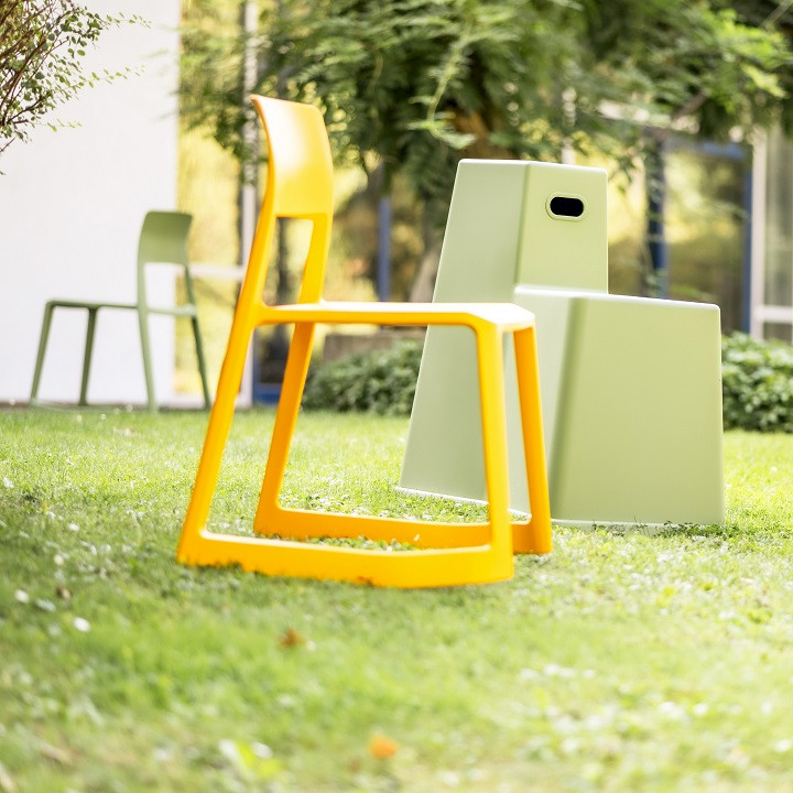 Gelber Hocker und grünes Stool Tool auf grüner Wiese